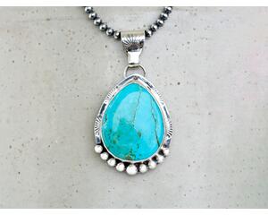 Front hanging view large blue turquoise pear cabochon bezel set accented with beads and stamped wire on oxidized navajo pearls 